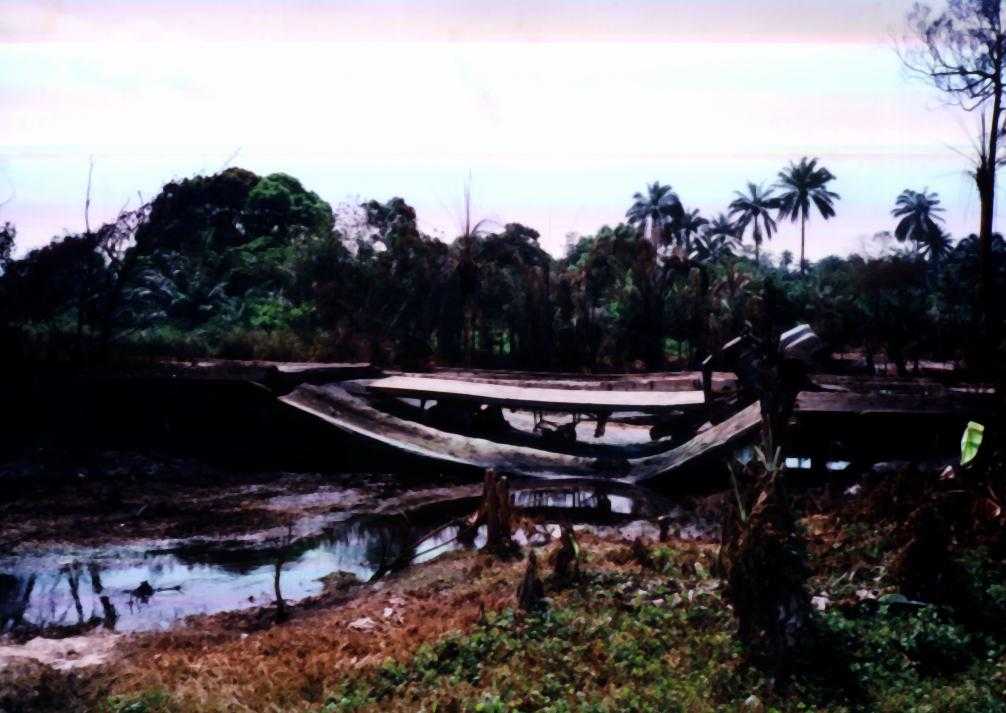 IMAGES FROM ELUME FIRE DISASTER IN URHOBO COUNTRY, NIGERIA'S NIGER DELTA, NOVEMBER 16, 2000: BURNT TRAILER ON A BROKEN BRIDGE